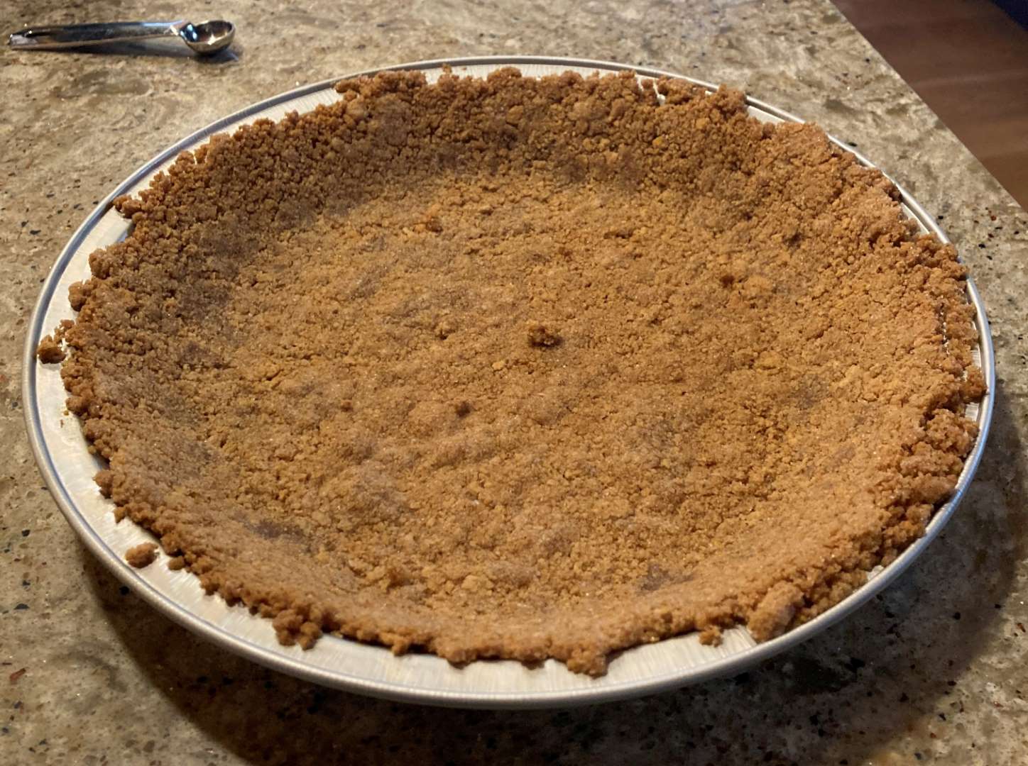 the empty shell of a homemade graham cracker pie crust